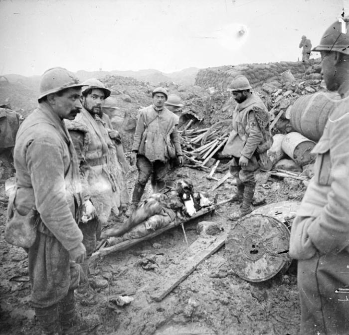 Sur la route de Verdun à Douaumont, un blessé grave est transporté vers un poste de secours par des brancardiers.