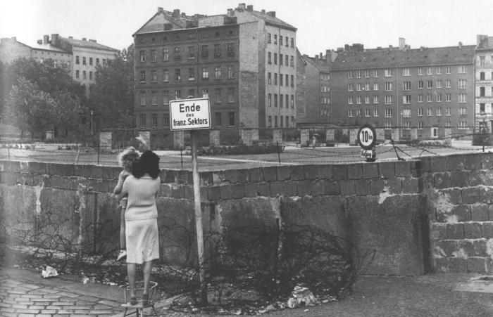 es milliers de Berlinois au désespoir se rassemblent, à la limite des secteurs, devant ce rempart qui, pour n’être encore composé que de barbelés et de chevaux de frise, ressemble déjà à un mur